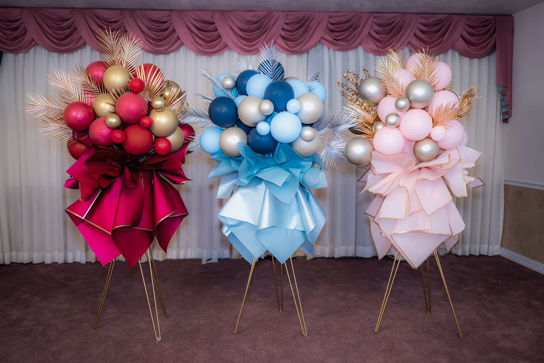 Three memorial standing arrangements shown together in red, blue, and blush palettes.